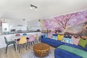 a living room with a blue couch and a table at Coral Island 102 in Bloubergstrand