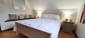 um quarto com uma cama grande com lençóis brancos e almofadas em La Bergerie em Stein