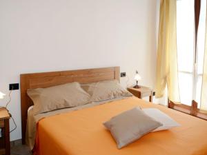 ein Schlafzimmer mit einem orangenen Bett mit zwei Kissen in der Unterkunft Apartment Noce - SBO103 by Interhome in Savona