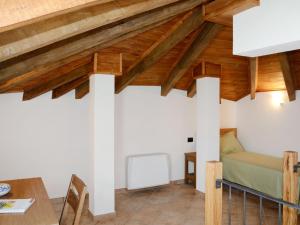 ein Schlafzimmer mit Holzdecken und ein Bett in einem Zimmer in der Unterkunft Apartment Noce - SBO103 by Interhome in Savona