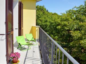 2 grüne Stühle auf einem Balkon mit Bäumen in der Unterkunft Apartment Noce - SBO103 by Interhome in Savona