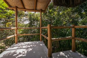 a porch of a hut with trees in the background at Pousada Colmeia - Praia de Santo André, Bahia in Santo André