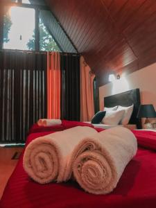 a bedroom with a red bed with towels on it at Water Side Residence in Adams Peak