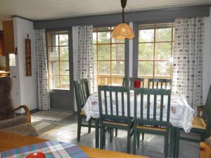 a dining room with a table and chairs and windows at Chalet Sandrabu - SOW056 by Interhome in Øyuvstad