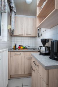 Una cocina con gabinetes de madera y encimera. en Apartment Schwalbennest V by Interhome, en Norddeich