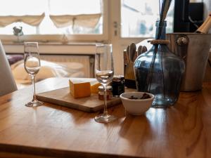 ノルトダイヒにあるApartment Schwalbennest V by Interhomeのワイングラス2杯とチーズ1杯付きテーブル
