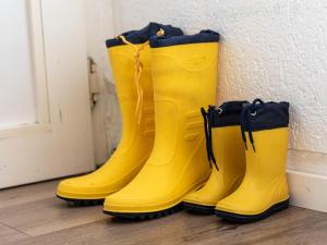 un grupo de botas amarillas de goma junto a una pared en Apartment Schwalbennest V by Interhome, en Norddeich