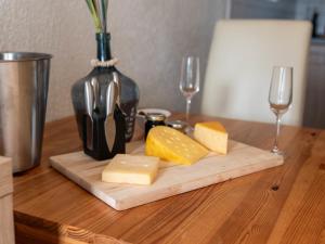 ノルトダイヒにあるApartment Schwalbennest V by Interhomeのチーズとワイン2杯のカッティングボード