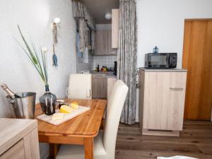 una pequeña cocina con una mesa de madera con queso. en Apartment Schwalbennest V by Interhome, en Norddeich