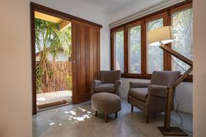 a living room with two chairs and a staircase at Pousada Colmeia - Praia de Santo André, Bahia in Santo André