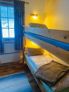 Etagenbett in einem Zimmer mit Fenster in der Unterkunft Sortland Camping og Motell AS in Sortland