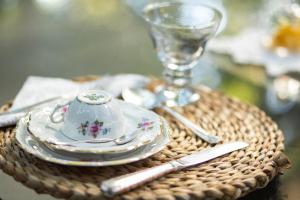 a table with a plate and a cup and a glass at Pousada Colmeia - Praia de Santo André, Bahia in Santo André