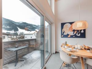 a dining room with a table and a large window at Apartment Das Georgen- Großglockner-Kitzsteinhorn by Interhome in Fürstau