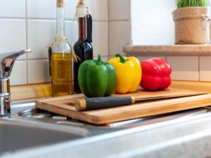 una tabla de cortar con tres pimientos en un mostrador de cocina en Apartment Möwe by Interhome en Norddeich