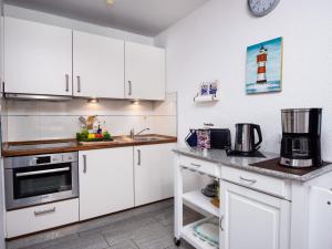 a kitchen with white cabinets and a counter top at Apartment Seerose by Interhome in Norddeich
