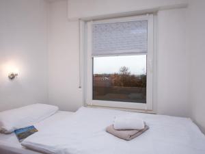 a bedroom with two beds and a large window at Apartment Seerose by Interhome in Norddeich