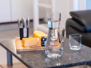 einen Mixer auf einem Tisch mit Käse und Weingläsern in der Unterkunft Apartment Seerose by Interhome in Norddeich