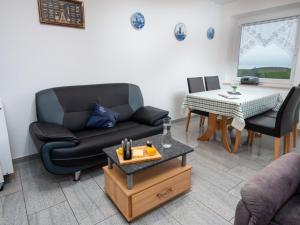 ein Wohnzimmer mit einem Sofa und einem Tisch in der Unterkunft Apartment Seerose by Interhome in Norddeich