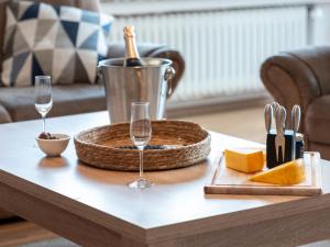 ノルトダイヒにあるApartment Teelke by Interhomeのワイングラス2杯とチーズが付いたテーブル