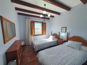 1 dormitorio con 2 camas y ventana en Casa Bayon, en El Paso