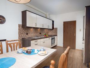 ノルトダイヒにあるApartment Teelke by Interhomeのテーブルと椅子のあるキッチンとダイニングルーム