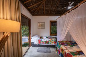 a room with two beds and a window at Pousada Colmeia - Praia de Santo André, Bahia in Santo André