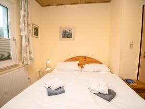 ノルトダイヒにあるHoliday Home Wind by Interhomeのベッドルーム1室(白いベッド1台、タオル2枚付)