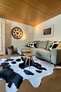 ein Wohnzimmer mit einem Sofa und einem Kuhteppich in der Unterkunft Apartment Linder by Interhome in Blankenburg