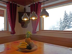 a table with a bowl of fruit and a window at Chalet Mioche by Interhome in Wengen