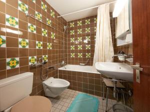 a bathroom with a toilet and a sink and a tub at Studio Combire 104 by Interhome in Les Collons