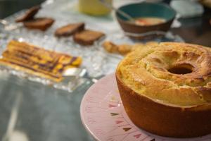 a cake sitting on a pink plate on a table at Pousada Colmeia - Praia de Santo André, Bahia in Santo André