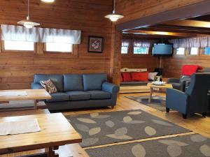 ein Wohnzimmer mit einem blauen Sofa und einem TV in der Unterkunft Holiday Home Petäjälahti by Interhome in Petäjävesi