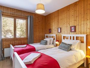 Duas camas num quarto com paredes com painéis de madeira em Apartment Brocard by Interhome em Val dʼIlliez