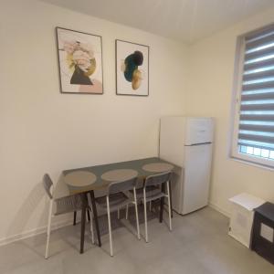 uma cozinha com uma mesa e cadeiras e um frigorífico em Apartament Wrzosowy Balkon Łódź em Lódź