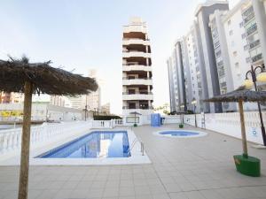 una piscina con 2 sombrillas y un edificio en Apartment Topacio IV-1 by Interhome, en Calpe 14 fotos más