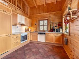 eine große Küche mit Holzschränken und einem Fenster in der Unterkunft Chalet Chalet Venus by Interhome in Patergassen