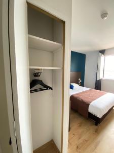 a small bedroom with a bed and a closet at Contact Hôtel des États-Unis in Toulouse
