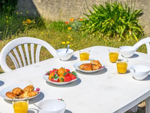 a white table with plates of food and glasses of orange juice at Holiday Home Pen-er-Park by Interhome in Carnac