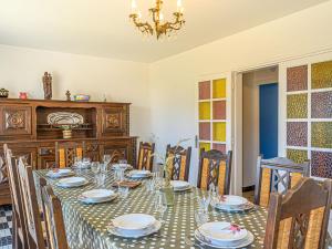 a dining room with a table with chairs and a chandelier at Holiday Home Pen-er-Park by Interhome in Carnac