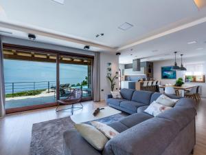 a living room with a couch and a large window at Villa Marone by Interhome in Dobreć