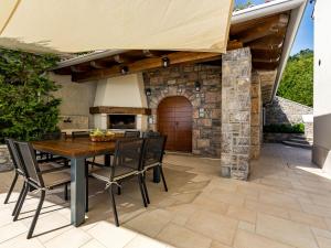 a patio with a wooden table and chairs and a stone oven at Villa Marone by Interhome in Dobreć