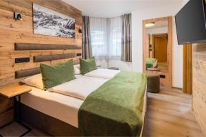 ein Schlafzimmer mit einem großen Bett in einem Zimmer in der Unterkunft Hotel Grüner Baum in Zell am See