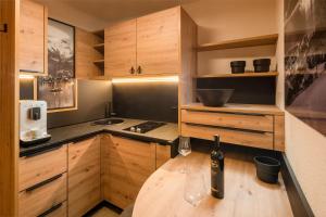 eine Küche mit Holzschränken und einem Holztisch mit Weingläsern in der Unterkunft Hotel Grüner Baum in Zell am See