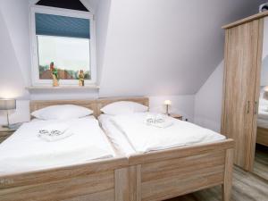 Schlafzimmer mit einem Bett mit weißer Bettwäsche und einem Fenster in der Unterkunft Holiday Home Aquantis by Interhome in Norddeich