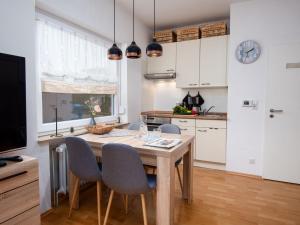 ノルトダイヒにあるApartment Meeresrauschen by Interhomeのキッチン(木製テーブル、椅子、テレビ付)