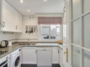 cocina blanca con fregadero y lavavajillas en Apartment Lorcrisur by Interhome, en Marbella