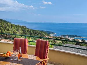 a table on a balcony with a view of the ocean at Holiday Home Drago by Interhome in Veliko Brdo