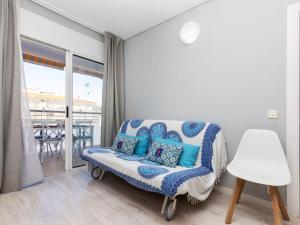 uma sala de estar com uma cadeira e uma varanda em Apartment Lotus by Interhome em Blanes