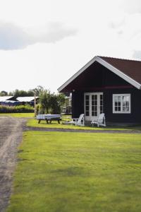 a black house with a picnic table and a bench at Holiday Home Natuurlijk de Veenhoop by Interhome in De Veenhoop