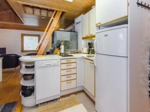 eine Küche mit einem weißen Kühlschrank in einem winzigen Haus in der Unterkunft Holiday Home Karjalan veikko 2 b by Interhome in Hattusaari